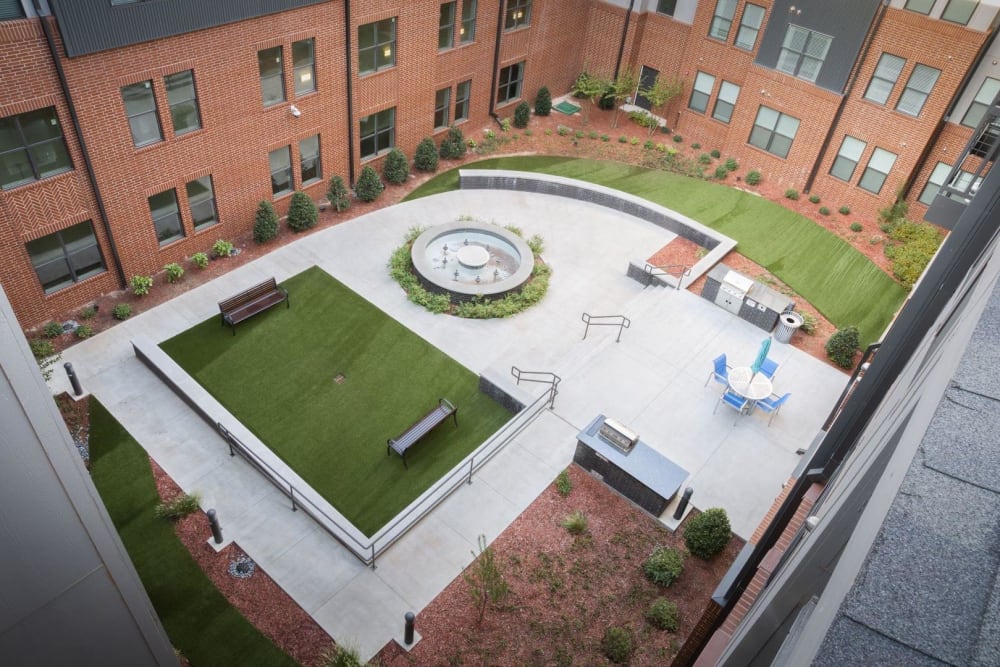 Courtyard with a grilling station, fountain, and grassy lawn at Steelyard in Oklahoma City, Oklahoma