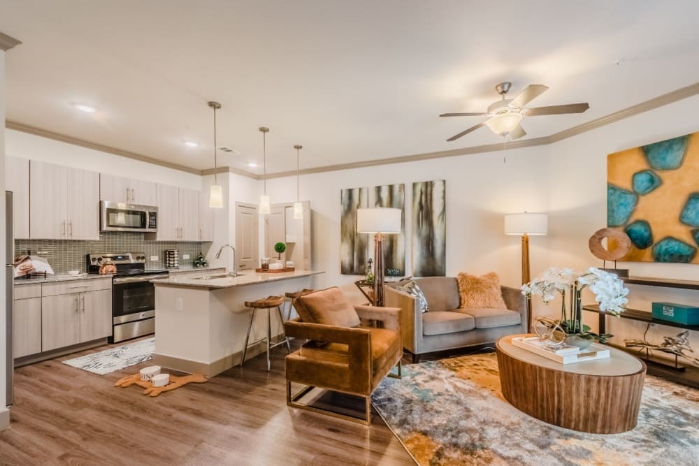 Upscale senior apartment with warm lighting and hardwood floors at Atlas Point at Prestonwood in Carrollton, Texas.