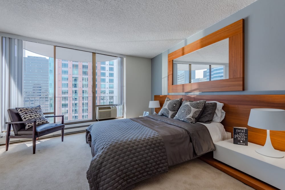 Floor-to-ceiling windows and an amazing city view from a model home's primary bedroom at Tower 801 in Seattle, Washington