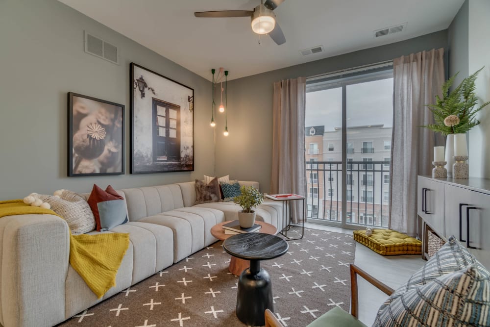 Spacious and well lit living room with a nice ceiling fan to keep you cool at The Flats at West Broad Village in Glen Allen, Virginia