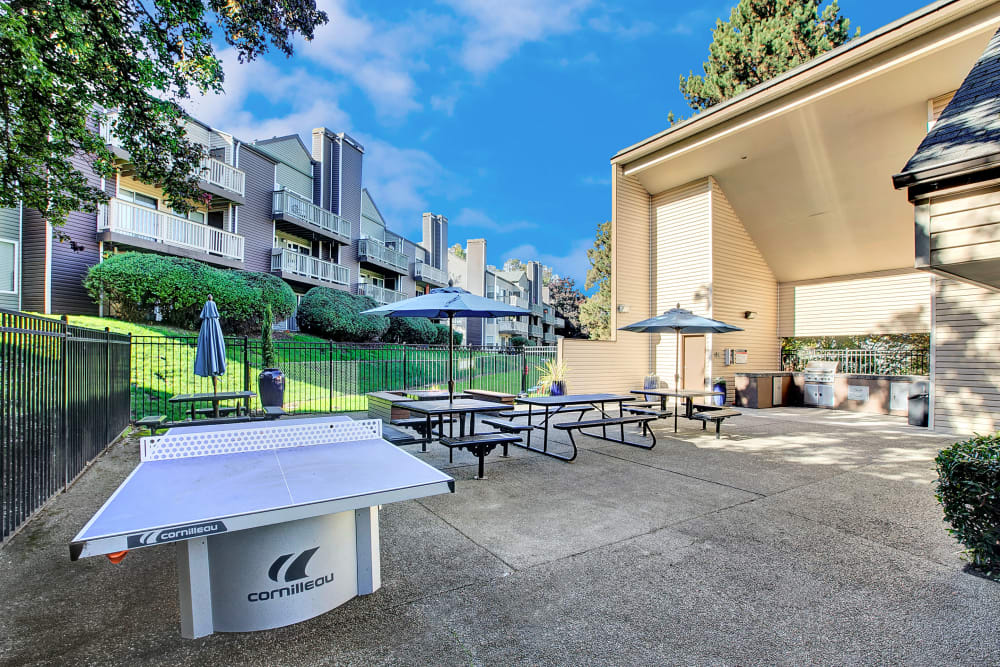 Barbecue area and outdoor ping pong table and fire pit at Park South Apartments in Seattle, Washington