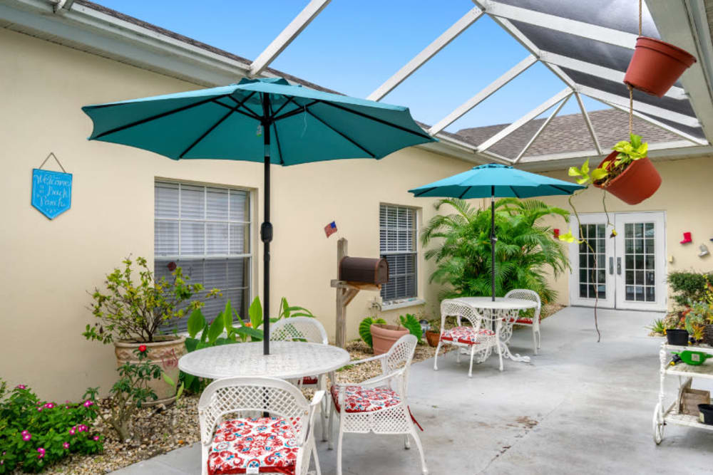 Tables and umbrellas in the courtyard at Truewood by Merrill, Bradenton in Bradenton, Florida