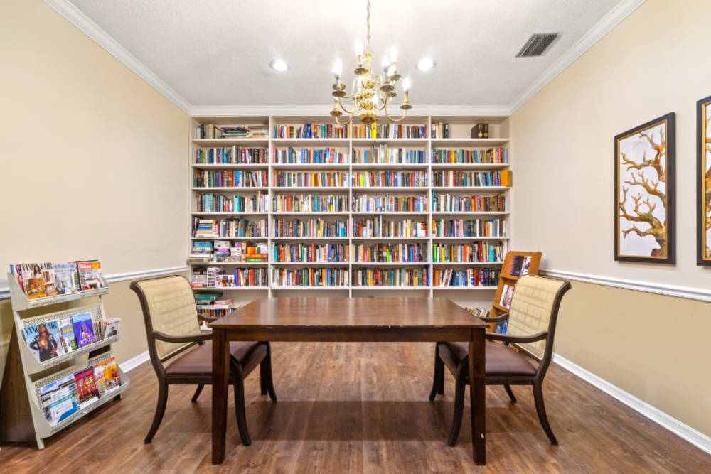 Table and a bookshelf in a small room at Truewood by Merrill, Bradenton in Bradenton, Florida