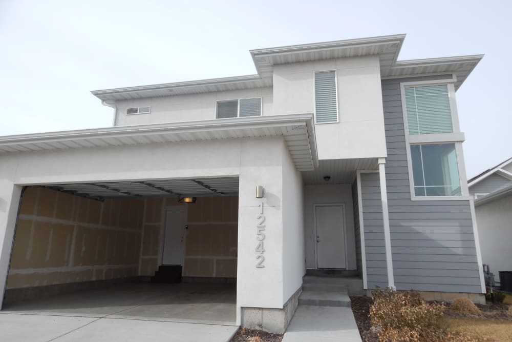 Two-story townhome with open two-car garage at Olympus at the Canyons in Herriman, Utah