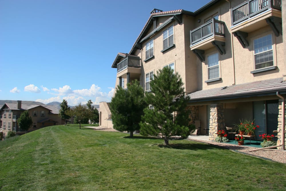Building exterior with private patio and greenspace at Montrachet Apartment Homes in Lakewood, Colorado