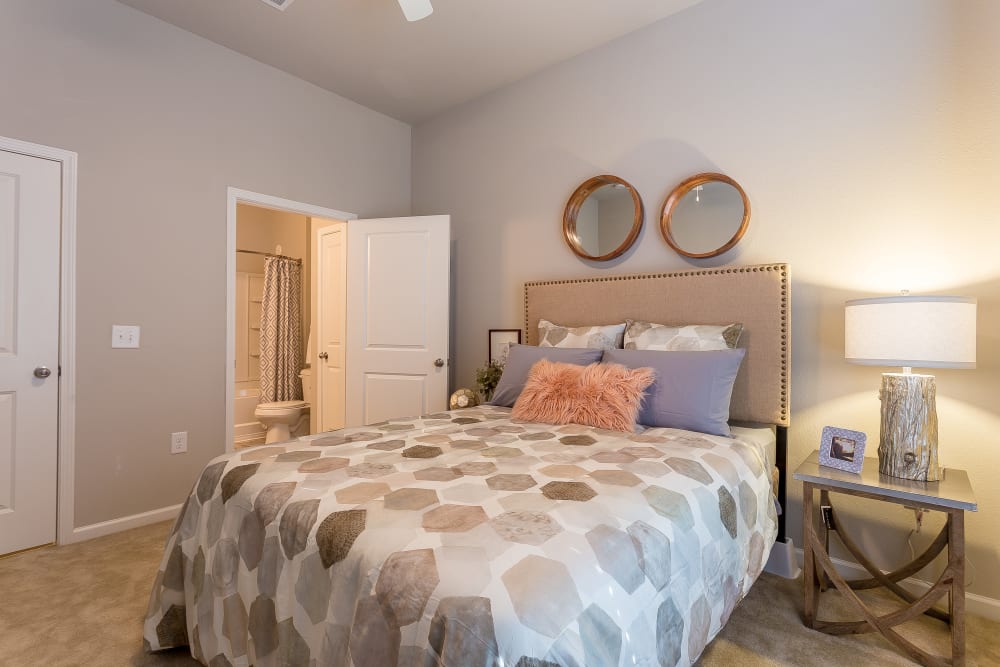 Model bedroom with ensuite bathroom at Creekside at Greenlawn Apartment Homes in Columbia, South Carolina