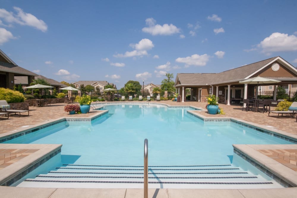 Resort-style swimming pool with sundeck and poolside veranda seating at Estates at McDonough Apartment Homes in McDonough, Georgia