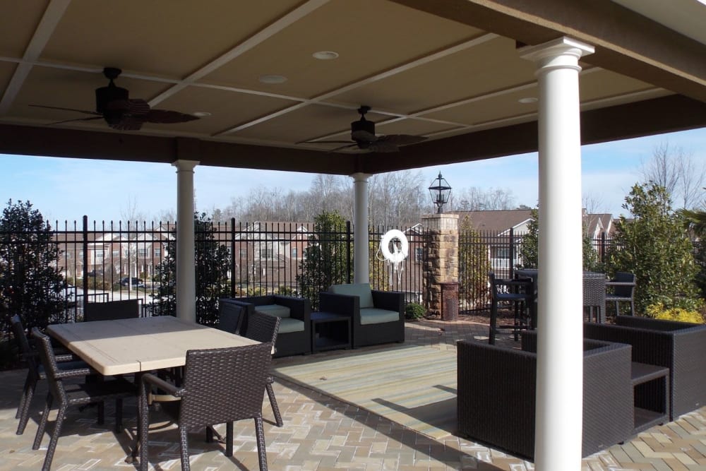 Outdoor pavilion with patio seating, fireplace, and grills at Estates at McDonough Apartment Homes in McDonough, Georgia