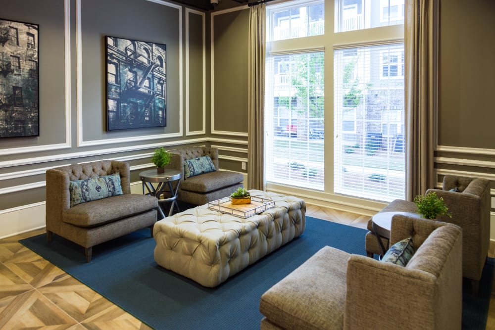 Comfortable seating area in front of large windows in the clubhouse at Haywood Reserve Apartment Homes in Greenville, South Carolina