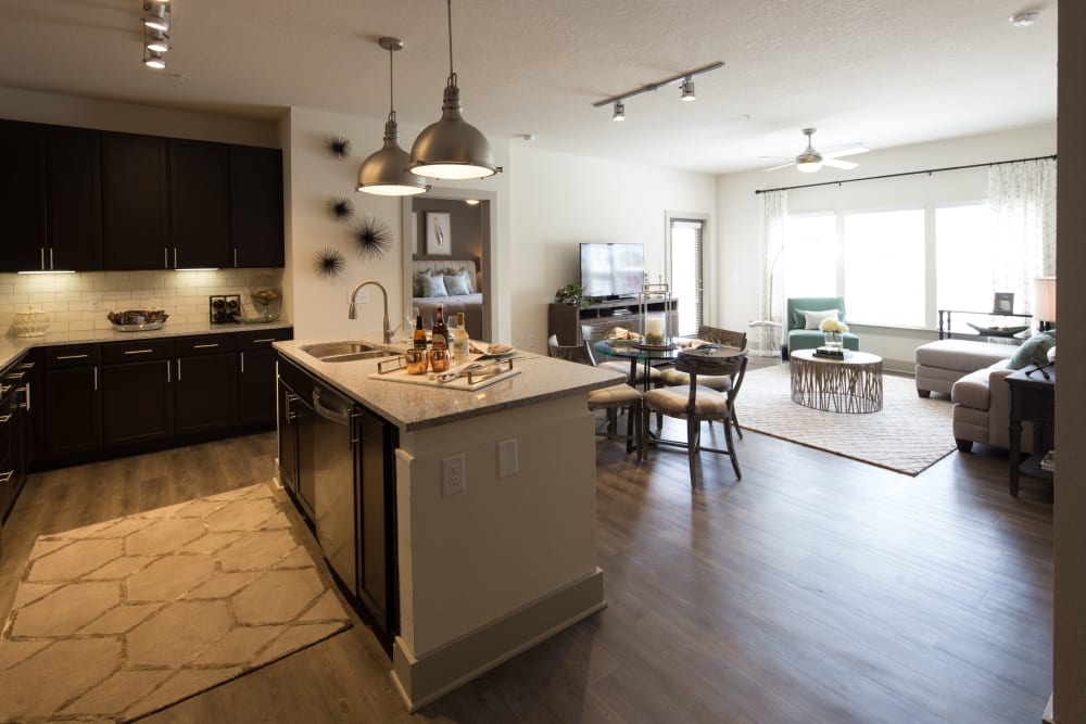 Open concept modern kitchen, dining area, and living room in a model apartment home at Haywood Reserve Apartment Homes in Greenville, South Carolina