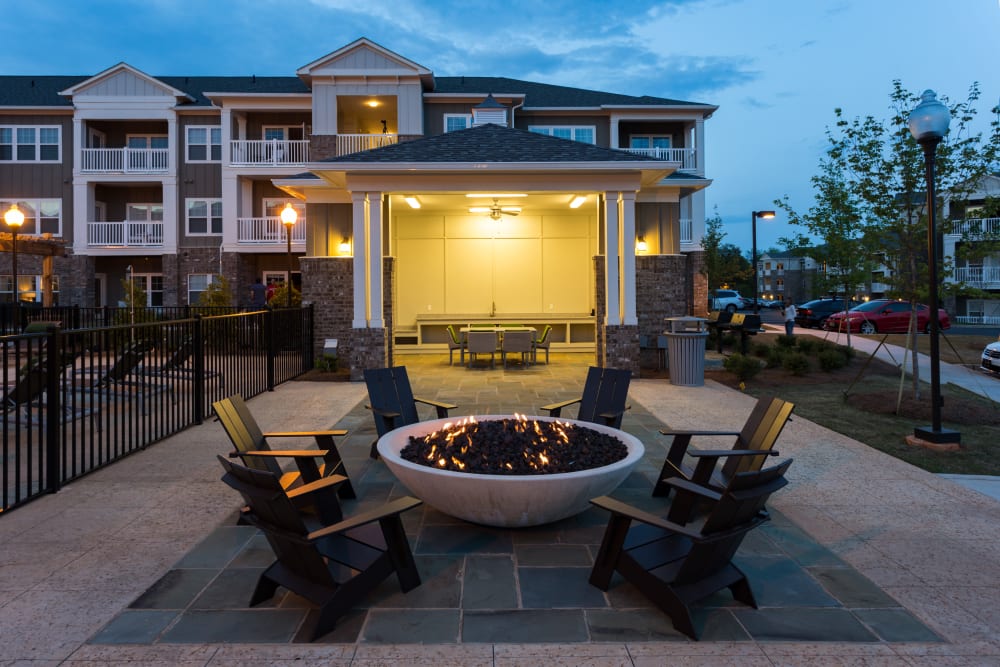 Firepit and outdoor kitchen and grilling stations at twilight at Haywood Reserve Apartment Homes in Greenville, South Carolina