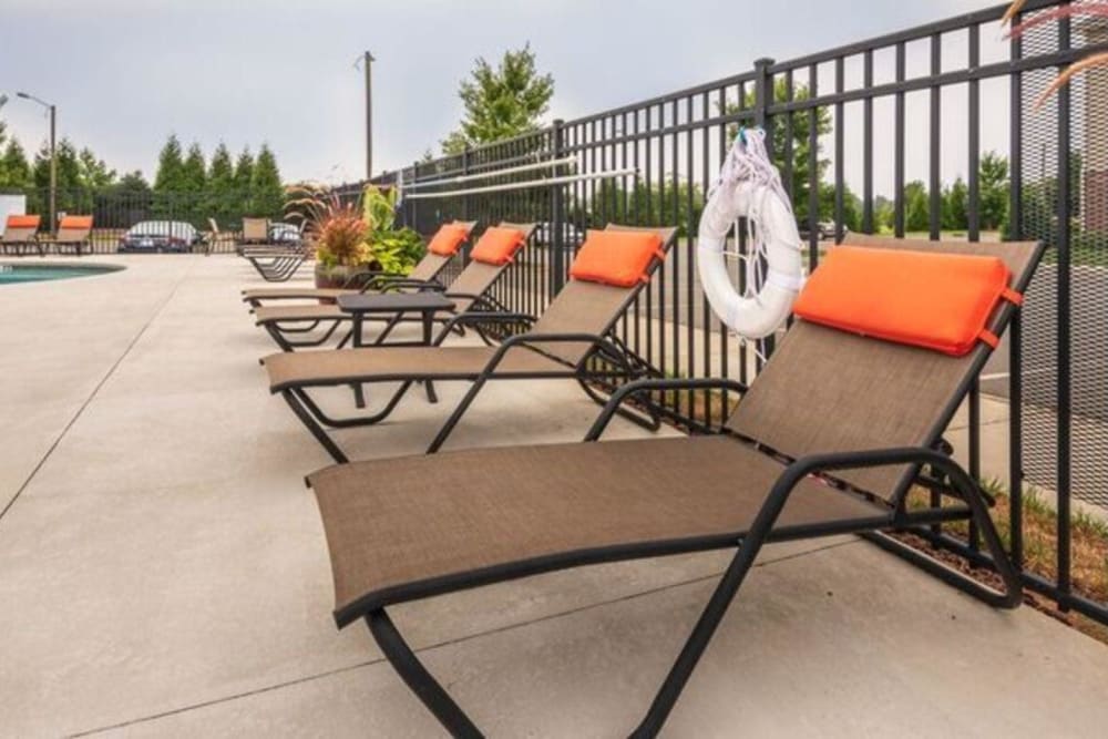 Comfortable poolside lounge chairs at Carden Place Apartment Homes in Mebane, North Carolina