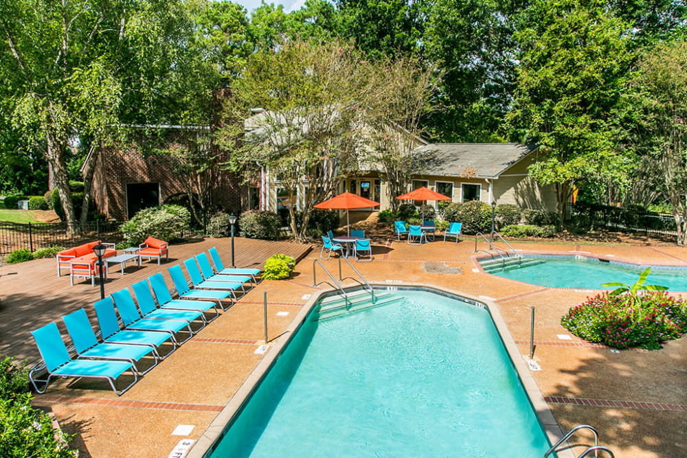 Two swimming pools with poolside lounge seating and patio tables at The Waterford Apartments in Columbia, South Carolina