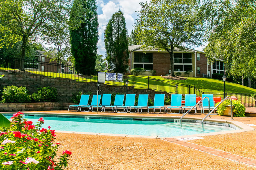 Sparkling swimming pool with poolside lounge chairs at The Waterford Apartments in Columbia, South Carolina