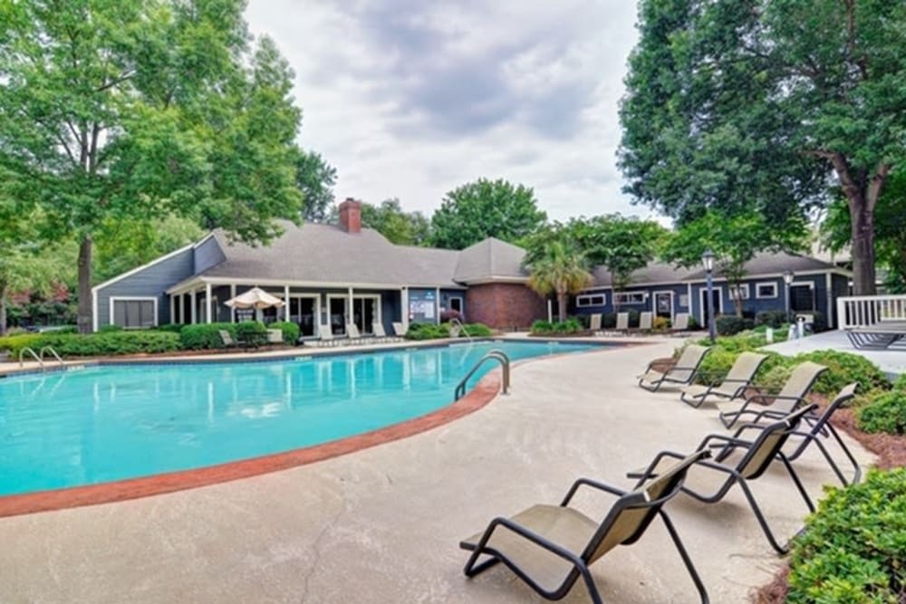 Resort-inspired swimming pool with plenty of poolside lounge chairs at St. Andrews Commons Apartment Homes in Columbia, South Carolina