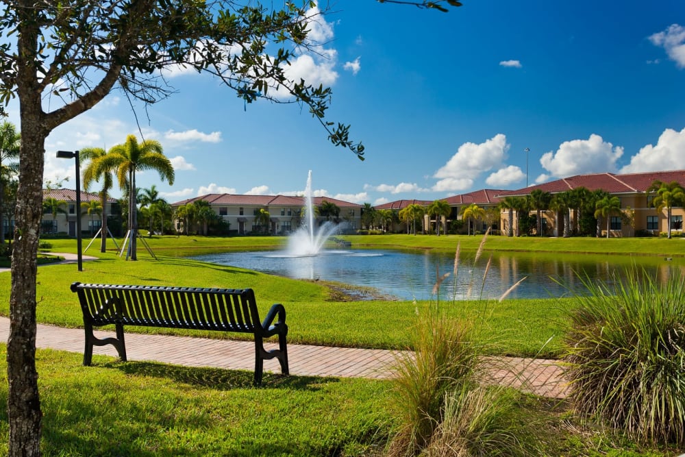 Bench beside a walking path along the lake at The Residences at Lakehouse in Miami Lakes, Florida