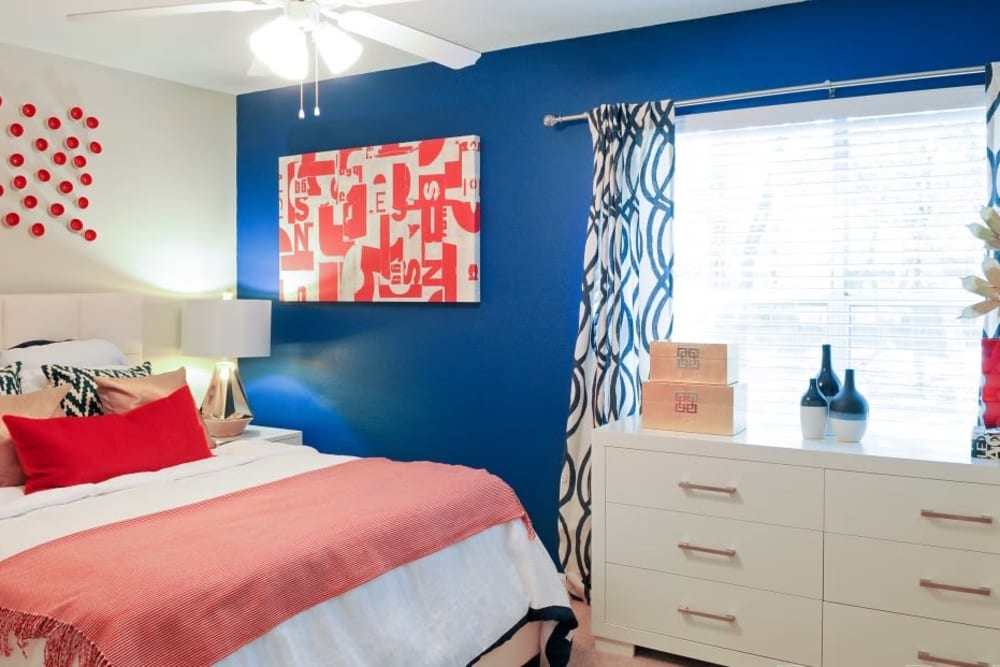 Well-lit model bedroom with plush carpeting and a ceiling fan at Hampton Greene Apartment Homes in Columbia, South Carolina