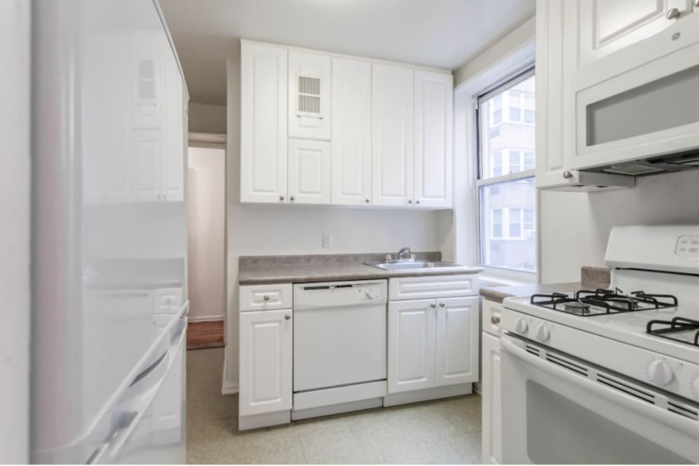 Spacious and well lit kitchen area with all white cabinets at Eastgold Westchester in Dobbs Ferry, New York