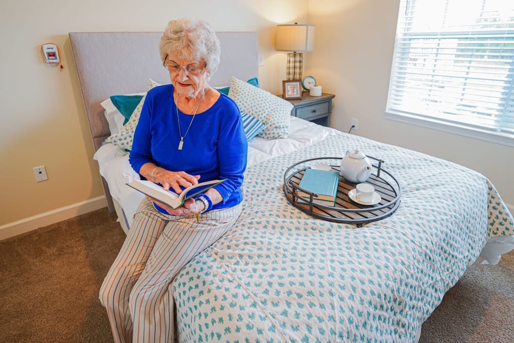 Resident reading in bedroom Harmony at Southridge in Charleston, West Virginia