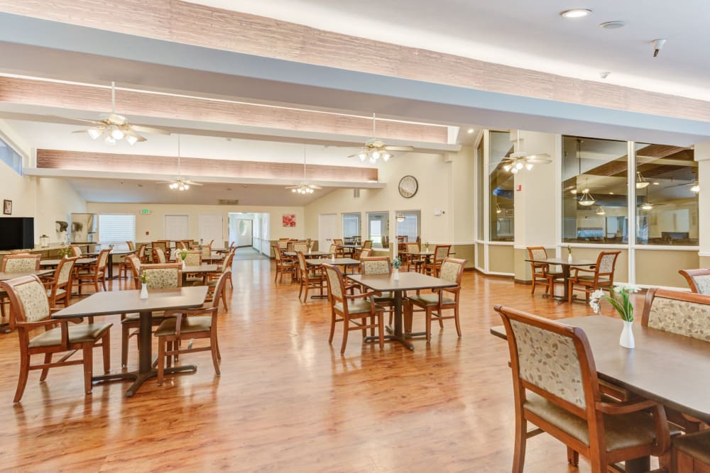 Community dining area with wood floors at Truewood by Merrill, Taylorsville in Taylorsville, Utah