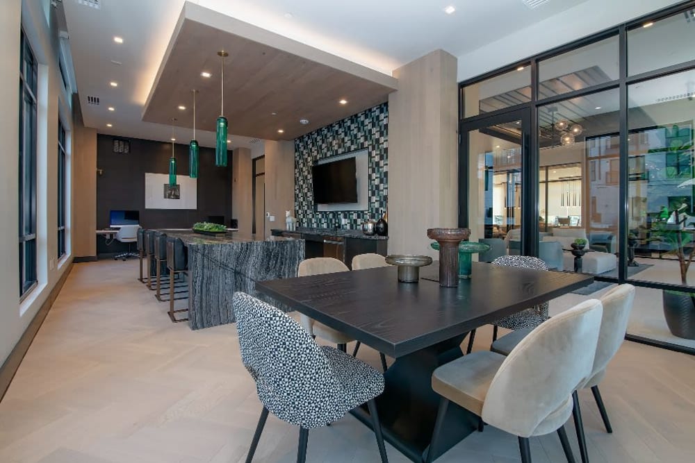 Lounge with a TV and sets of tables and chairs at Vidorra McKinney Avenue in Dallas, Texas