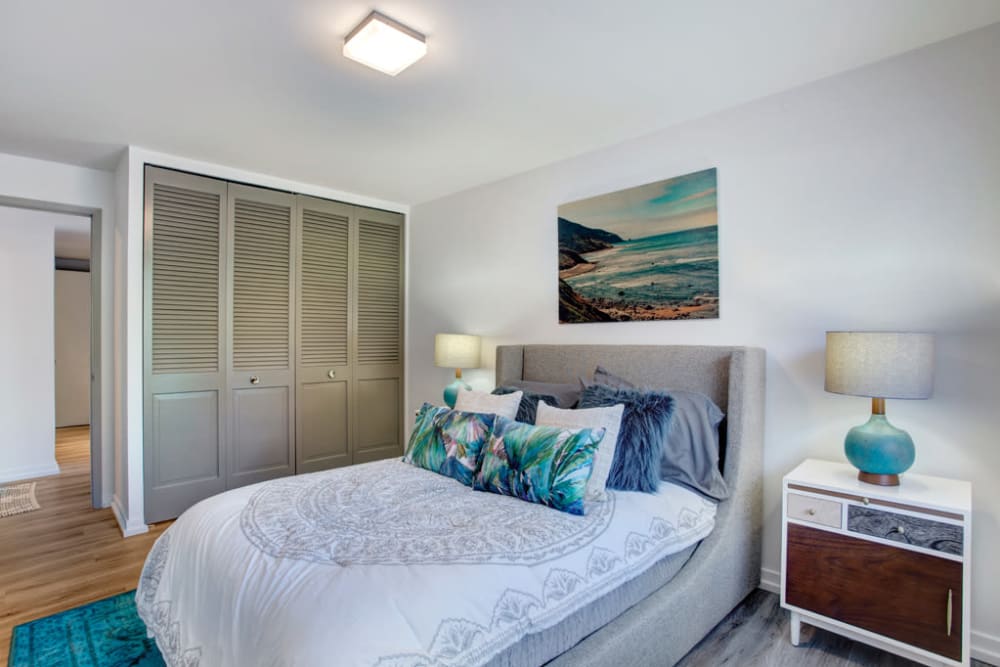 Bedroom with comfortable bed at Panorama Apartments in Seattle, Washington