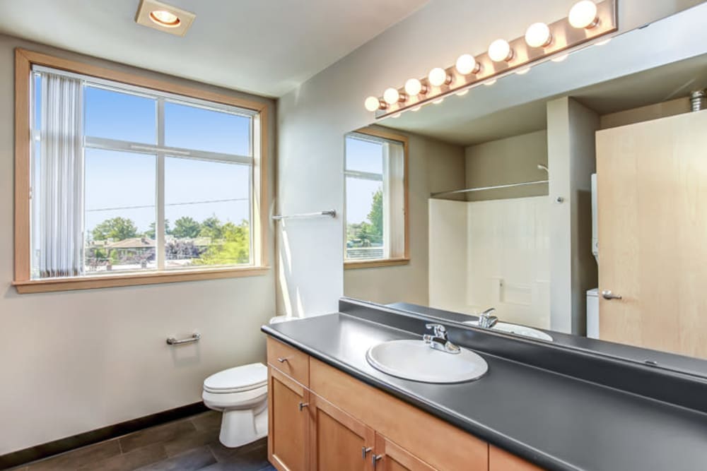 Large vanity mirror and a quartz countertop in a model apartment's bathroom at 700 Broadway in Seattle, Washington