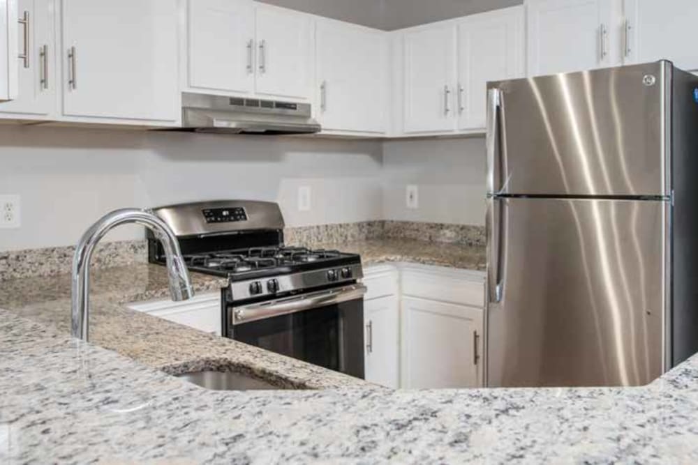 Stainless steel appliances and granite style countertops in the sleek modern looking kitchen at The Village of Churchills Choice in Upper Marlboro, Maryland