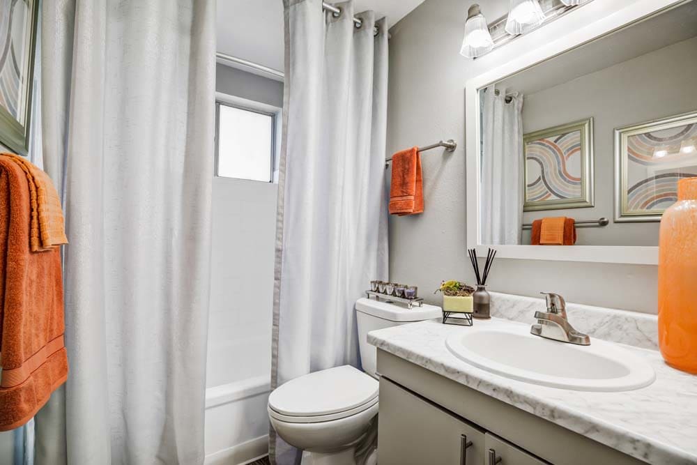 A clean, brightly-lit bathroom at Ten 30 and 49 Apartments in Broomfield, Colorado