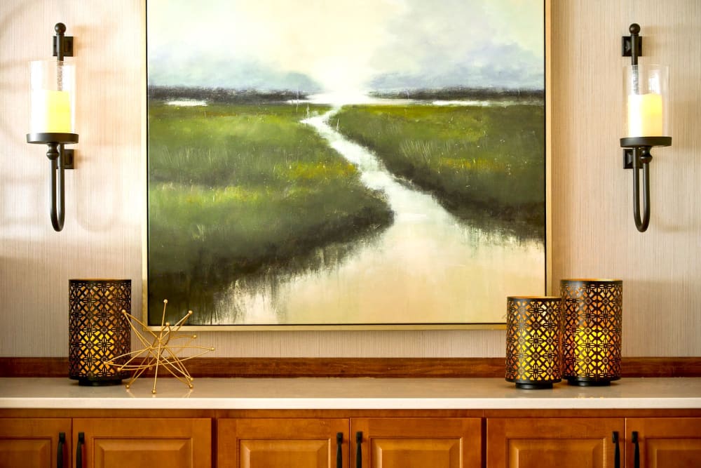 Landscape Painting with two candle holders hung beside it on a wall at Amira Choice Roseville in Roseville, Minnesota