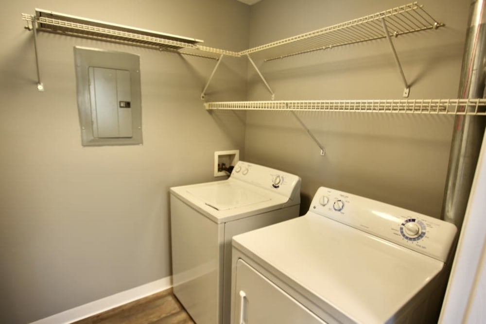 Laundry room with full size washer and dryer in an apartment home at Trotter's Landing in Delaware, Ohio