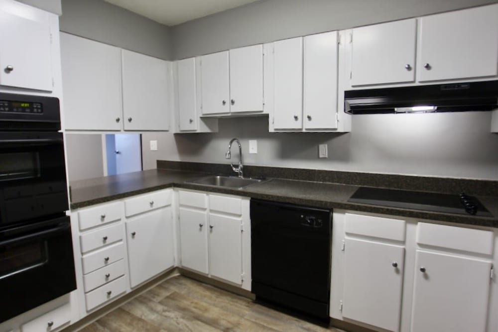 Upgraded modern kitchen with white cabinetry and black appliances including a dishwasher at The Canterbury in Columbus, Ohio