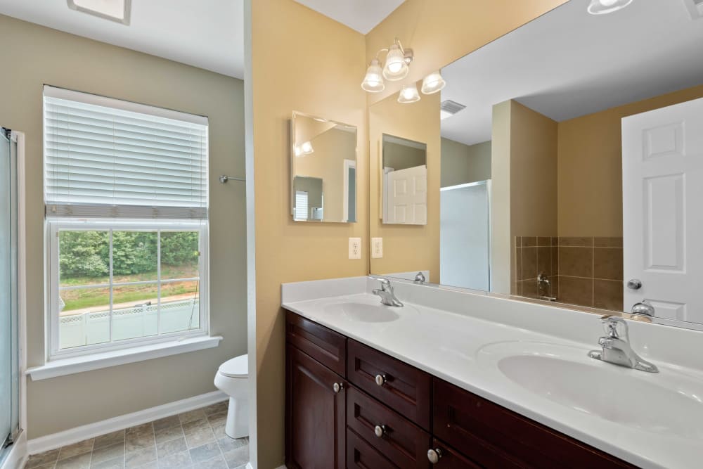 A bathroom with dual sinks and a large window at Columbia Colony in Patuxent River, Maryland