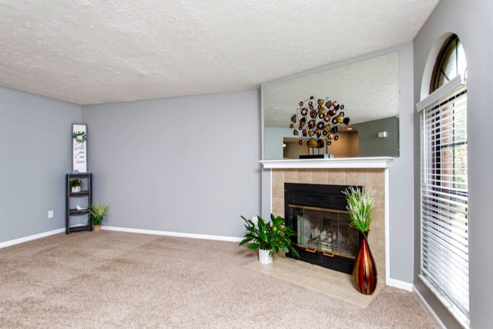 Carpeted living room with a gas fireplace at McNaughten Woods in Columbus, Ohio