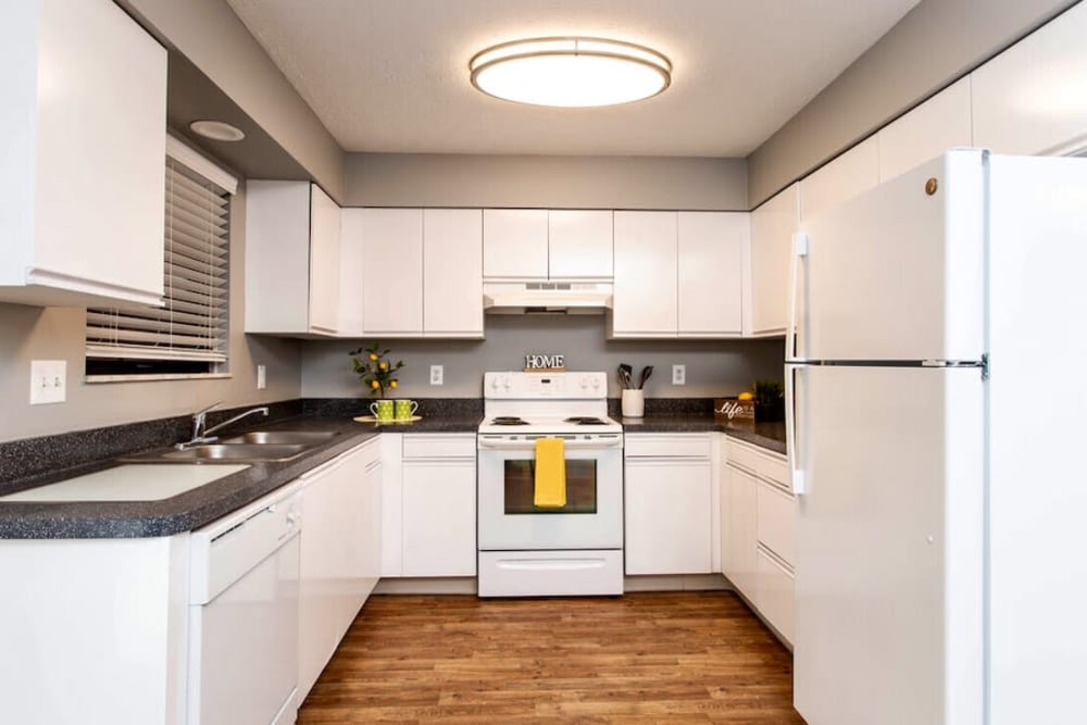 Fully equipped kitchen with white cabinetry and appliances at McNaughten Woods in Columbus, Ohio