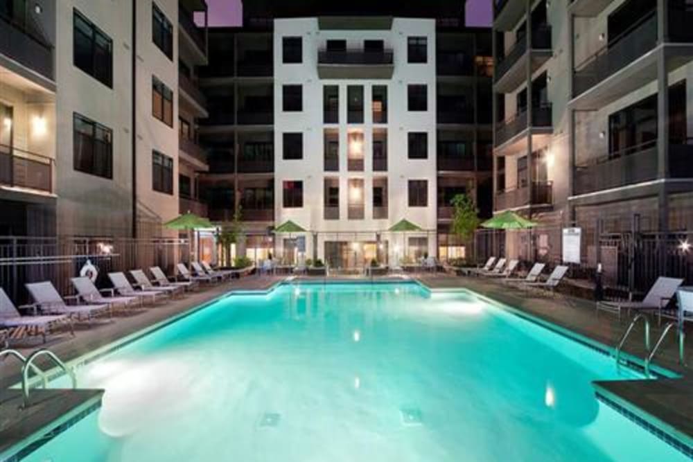 Community pool at night glowing with underwater lighting at eon at Lindbergh in Atlanta, Georgia