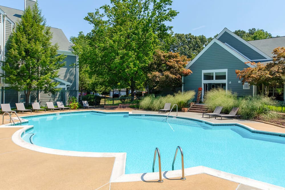 Outdoor community pool lined with sun lounge chairs at Hunter's Glen in Upper Marlboro, Maryland