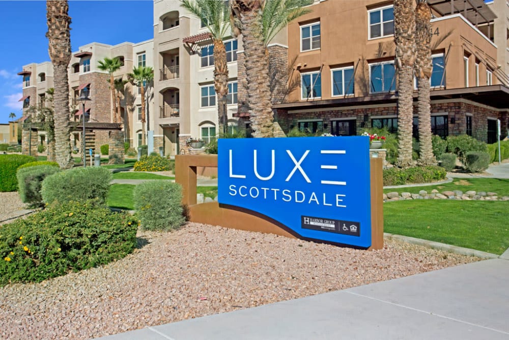 Location signage by the driveway at Luxe Scottsdale Apartments in Scottsdale, Arizona