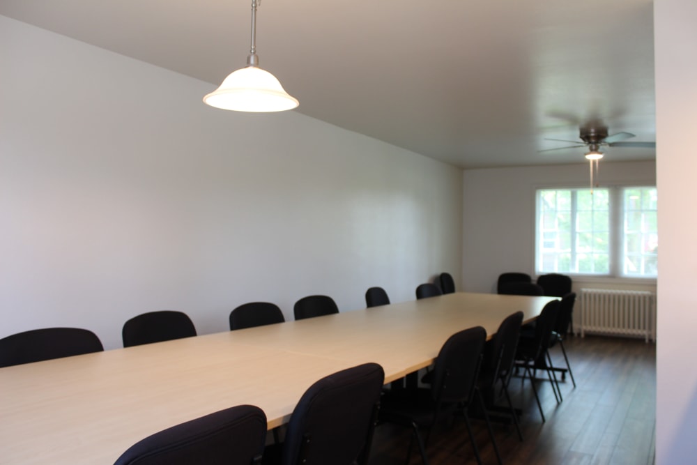 A well-lit meeting room with a table and chairs at The Bricks in Joint Base Lewis-McChord, Washington