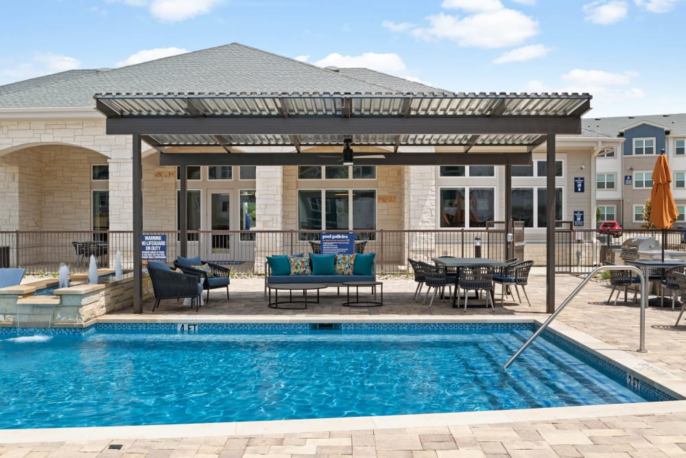 Covered patio seating by the pool at Linden Ranch in Sachse, Texas