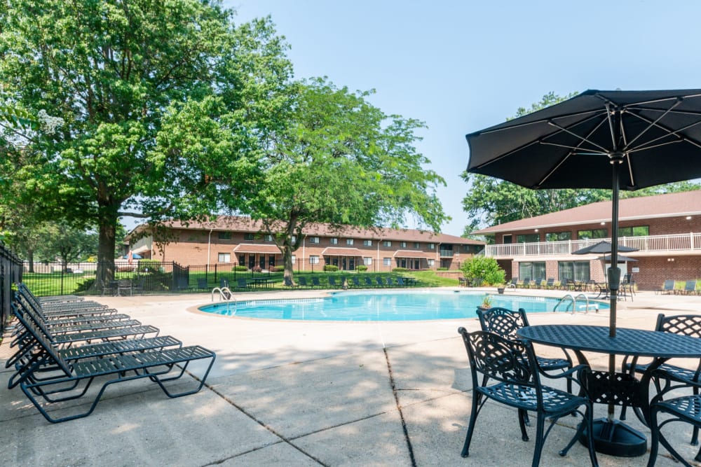 Shaded seating poolside at Racquet Club Apartments and Townhomes in Levittown, Pennsylvania