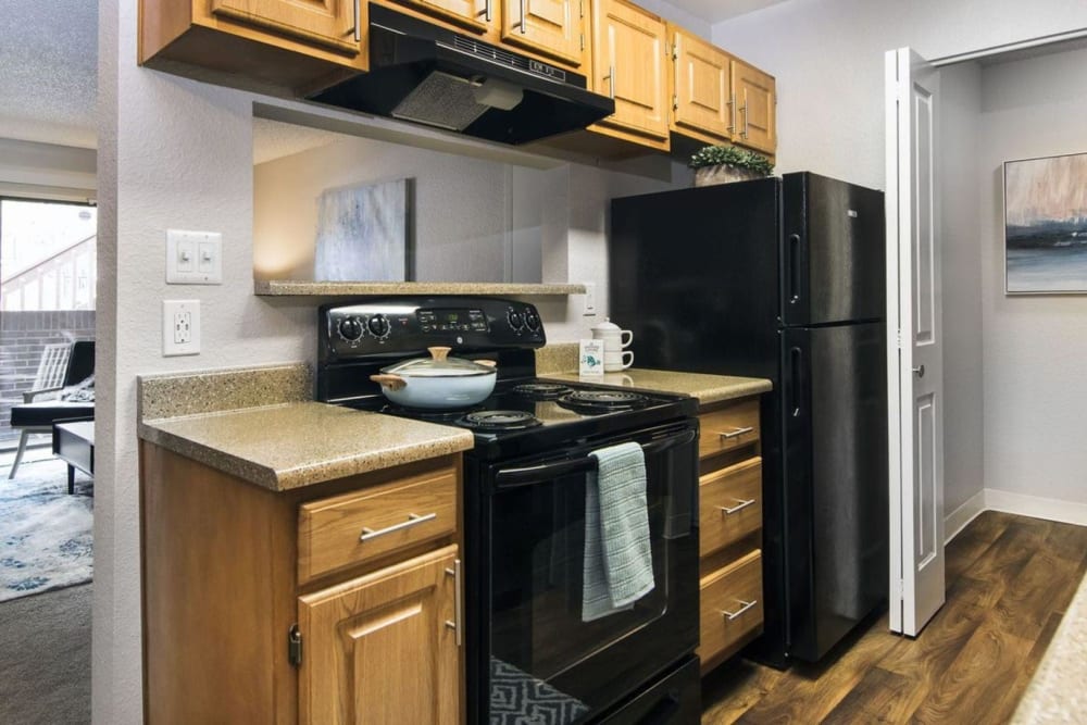 Light style wood cabinets in the kitchen that go nicely with the black appliances at Sofi Belmar in Lakewood, Colorado