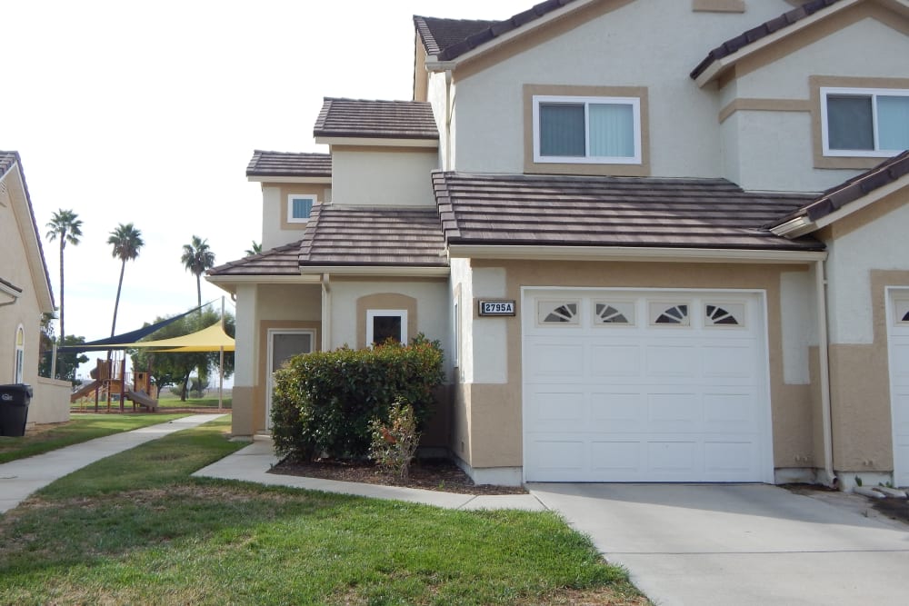A home with a garage and landscaping at Midway Park in Lemoore, California