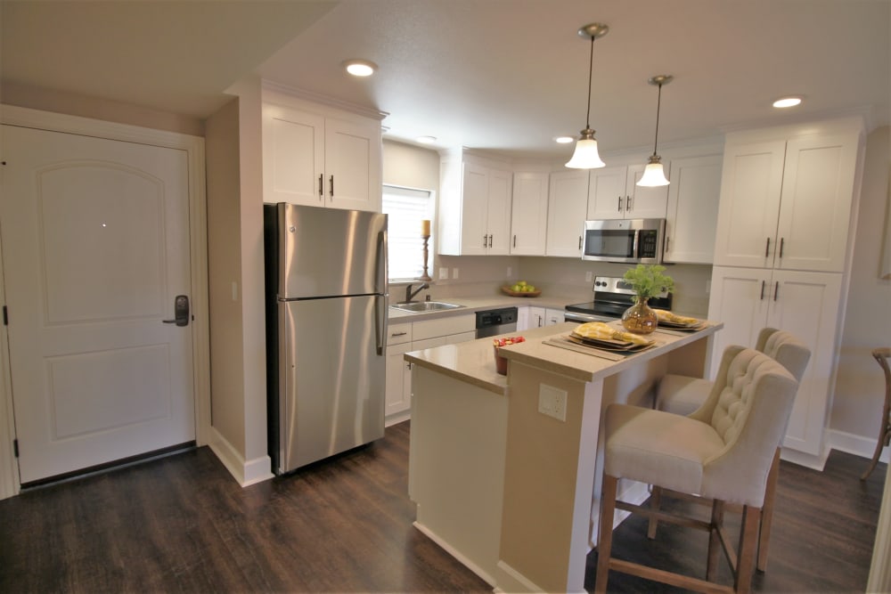 Model kitchen with stainless-steel appliances and wood-style flooring at Ramblewood Apartment Homes in Fremont, California