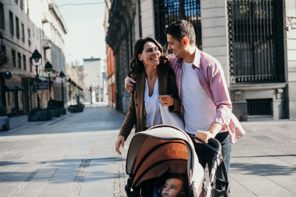 Couple and their newborn out for a stroll through the neighborhood near Anden in Weymouth, Massachusetts