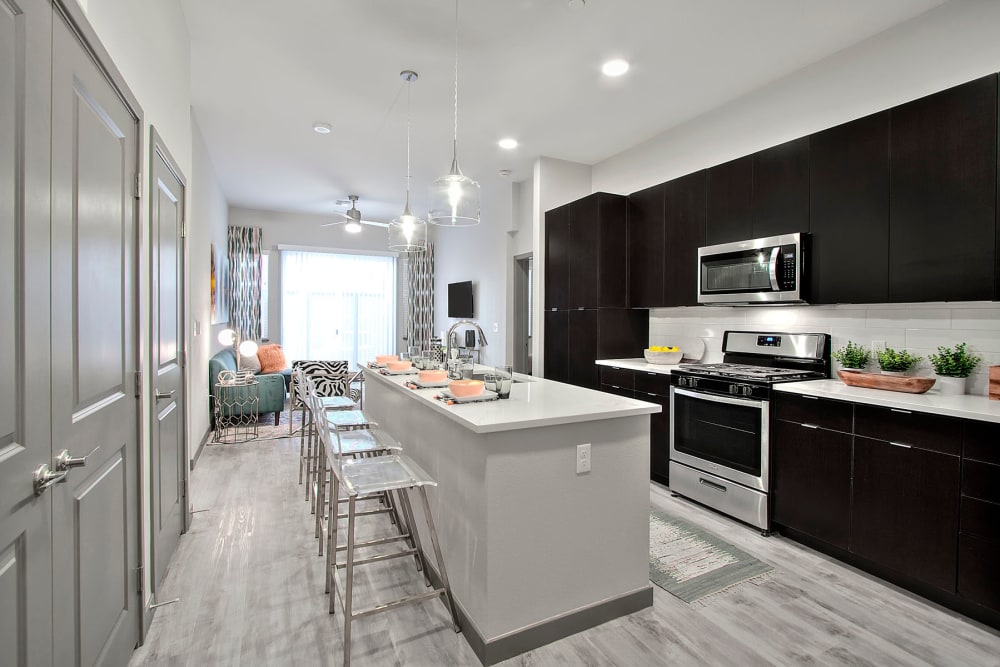 Gourmet kitchen with quartz countertops and pendant lighting in a model home at Jade Apartments in Las Vegas, Nevada