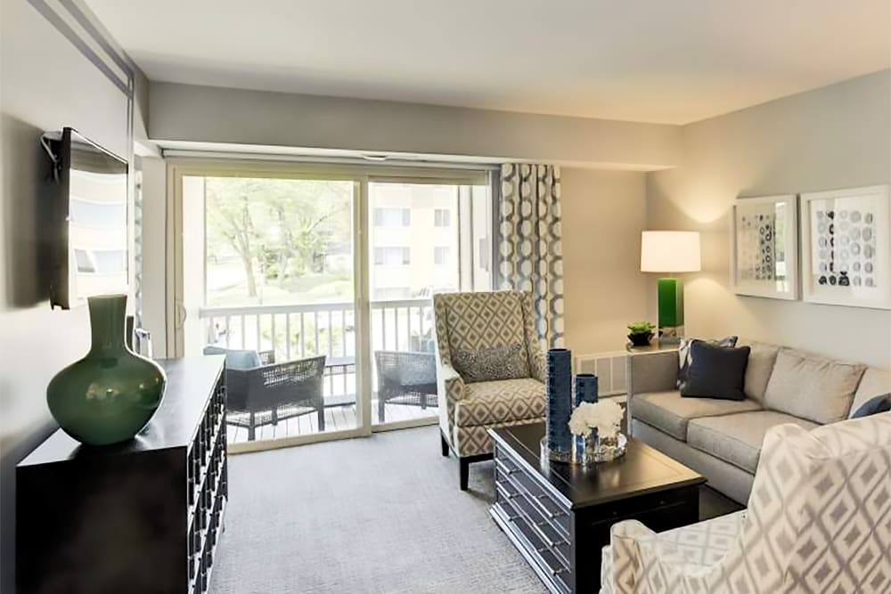 Nicely furnished model living room with private balcony at Satyr Hill Apartments in Parkville, Maryland