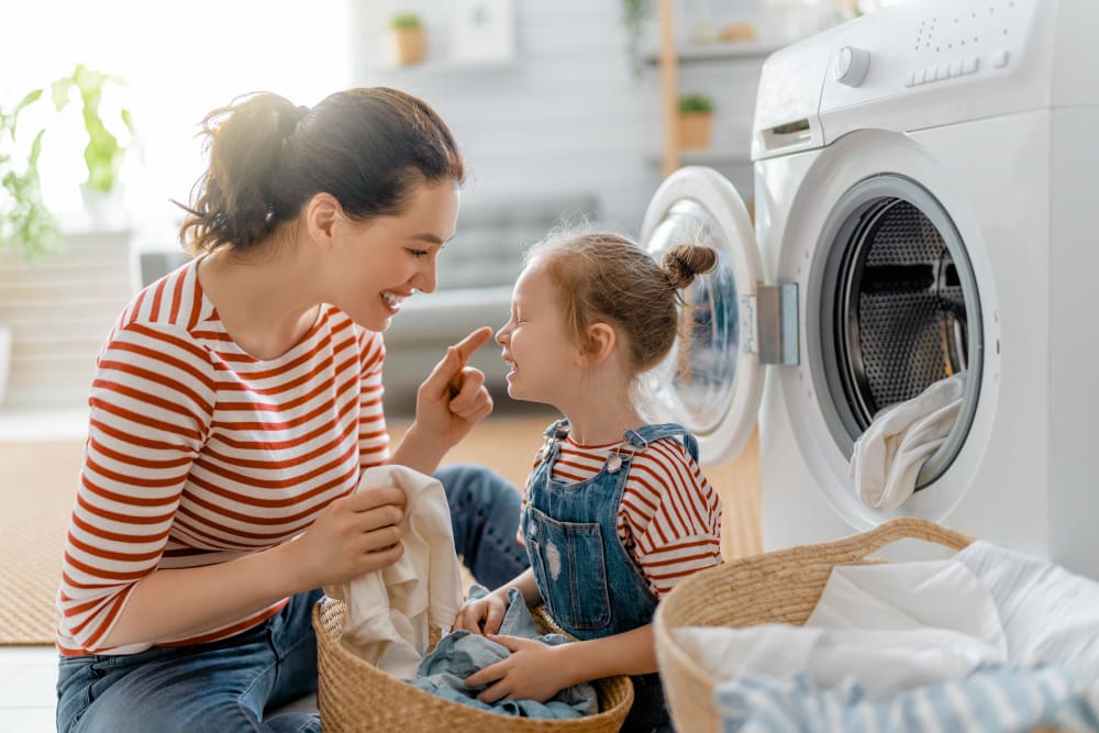 Mother and daughter happily doing laundry at Satyr Hill Apartments in Parkville, Maryland