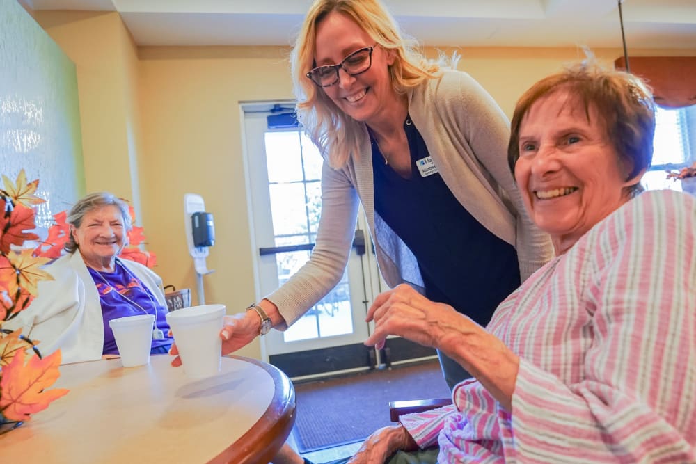 Associate talking with residents at happy hour at Harmony at West Shore in Mechanicsburg, Pennsylvania