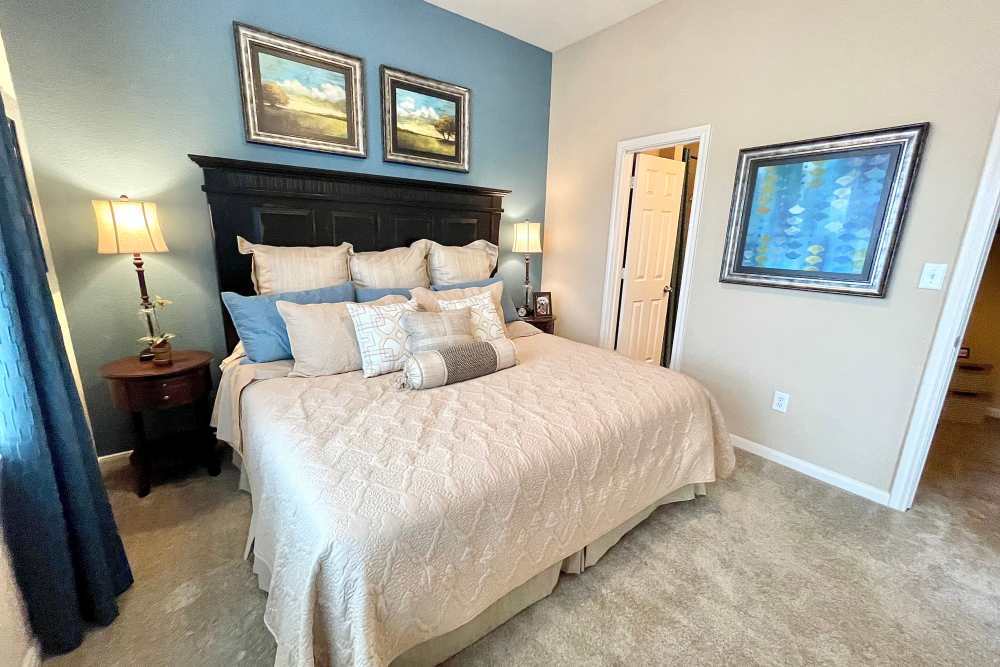 Bedroom with designer light fixtures at The Abbey at Stone Oak in San Antonio, TX